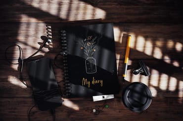 Spiral Notebook On Wooden Surface With Hard Shadow Mockup