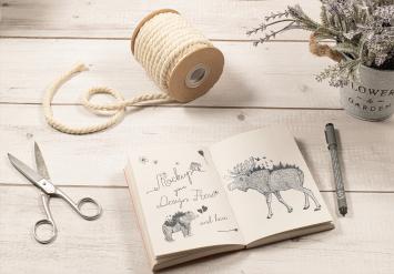 Sketch Notebook Mockup on a White Wood Table with Ornaments